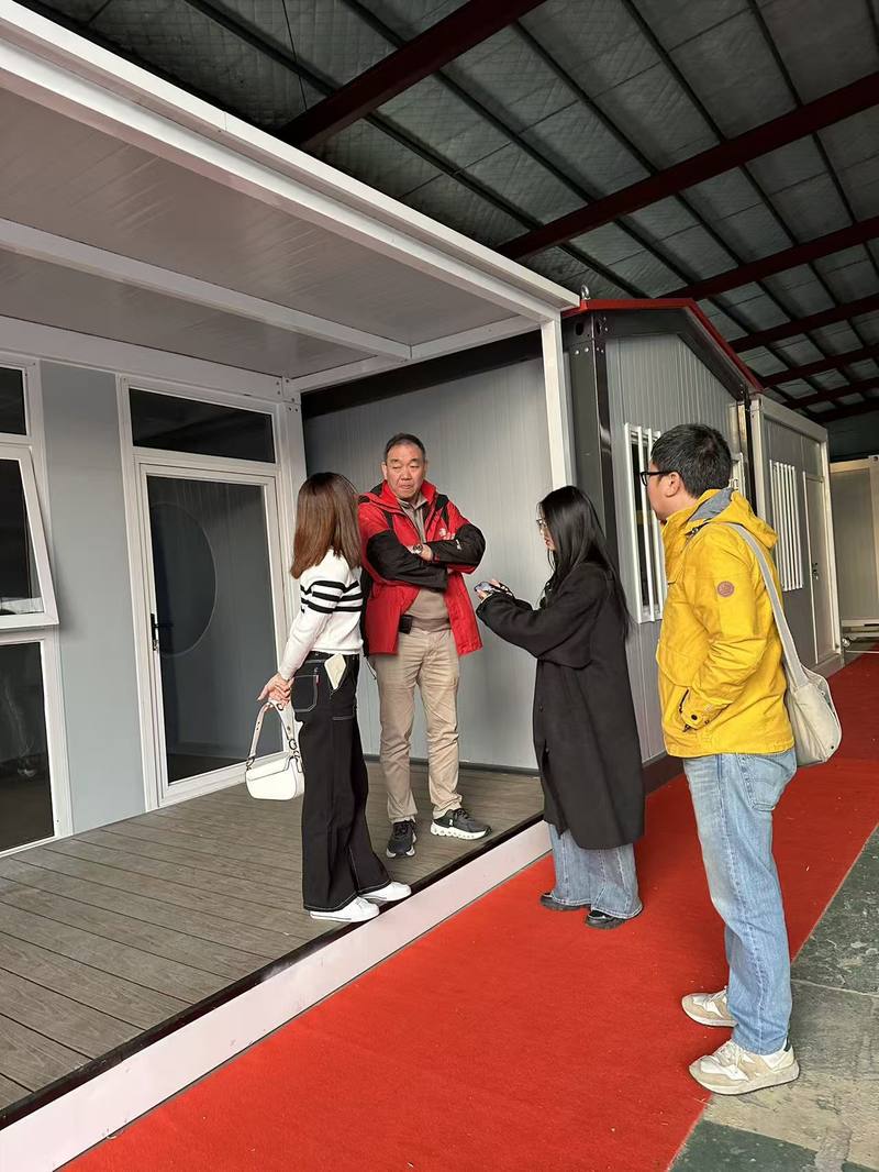 Client inspecting the exterior of a completed container house unit in the Taimao factory showroom